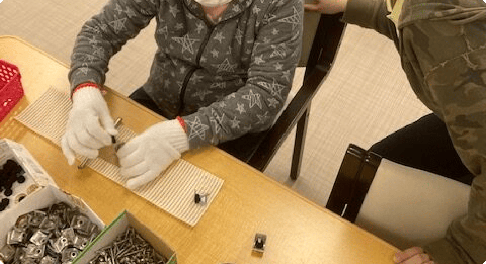 細かい部品の仕分けや組み立て作業を行っている様子